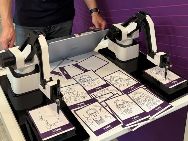 Two AI drawing robots creating guest portraits live at a corporate event in the Netherlands
